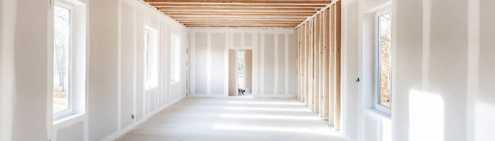 Empty interior of new construction house with drywall and wooden framing