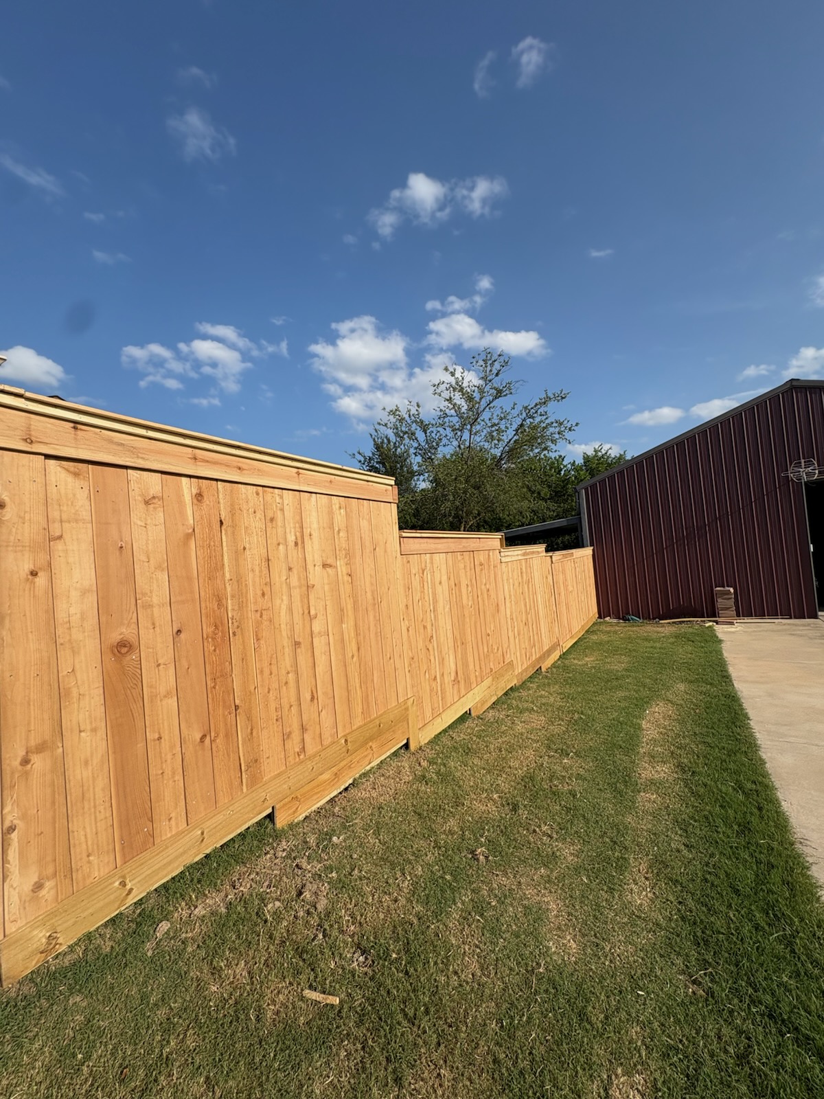 New cedar privacy fence stepping down a sloped side yard